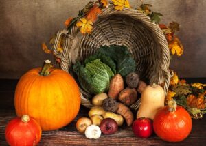 Basket with pumpkins, squash, tomatoes, and other seasonal vegetables